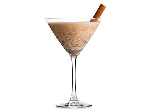 Martini glass filled with pumpkin spice, garnished with a cinnamon stick