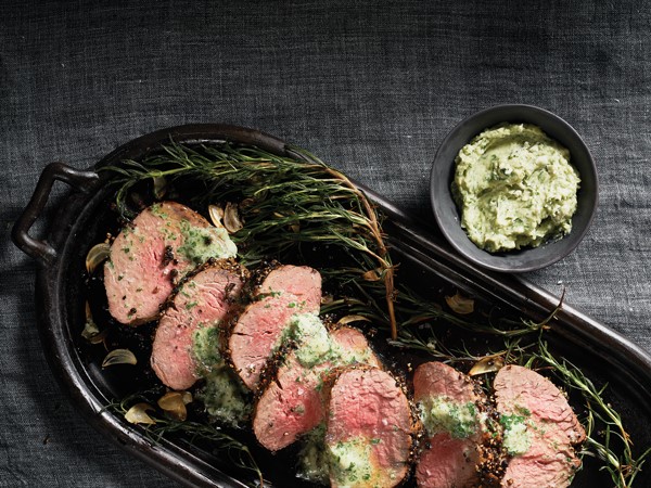 Platter of herbed beef tenderloin served with a side dish