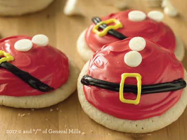 Sugar cookies covered in red icing and decorated with candy and black and yellow icing 