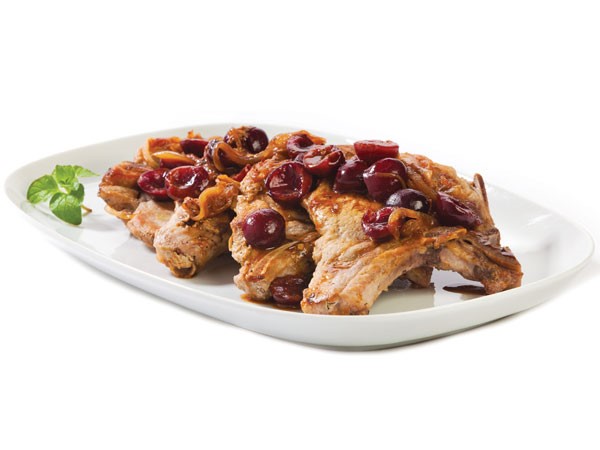 Platter of pork chops garnished with cherries and glaze