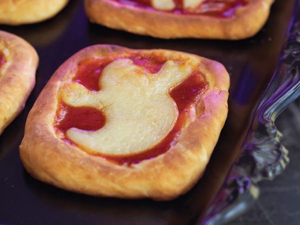Mini rectangle pizzas topped with ghost-shaped pizza dough