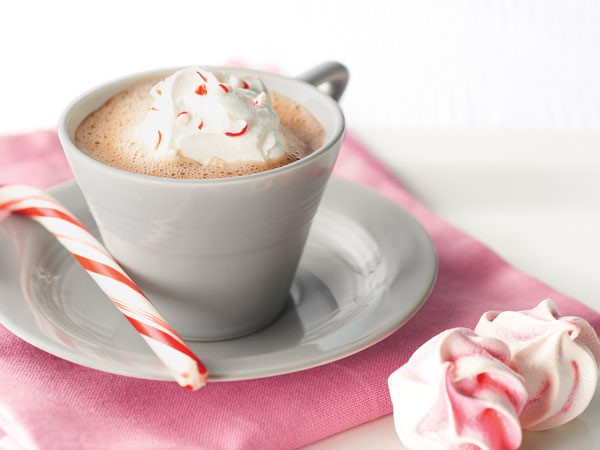 Cup of mocha topped with whipped topping and crushed candy cane, served with a candy cane