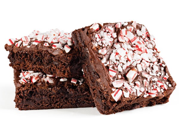 Chocolate brownies topped with chocolate frosting and crushed candy cane pieces 