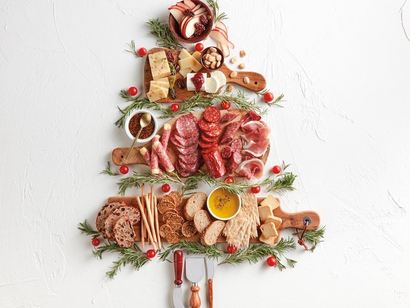 Tree made out of cutting boards, cheese, hard meats, rosemary, and fruits