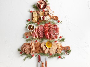 Tree made out of cutting boards, cheese, hard meats, rosemary, and fruits