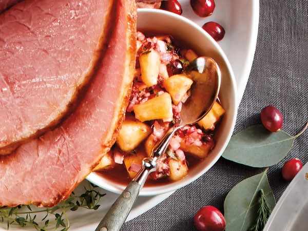 Sliced ham served with side of pineapple cranberry salsa
