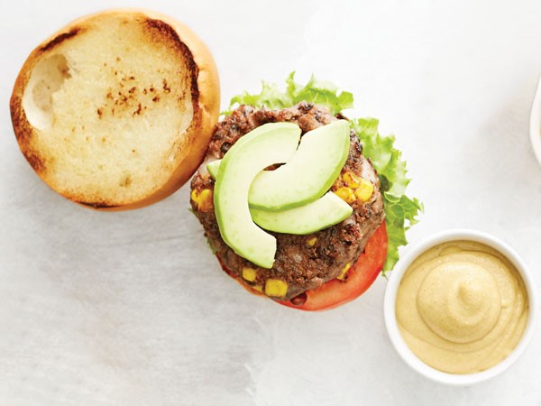 Black bean burgers topped with avocado slices or caramelized onions on buns