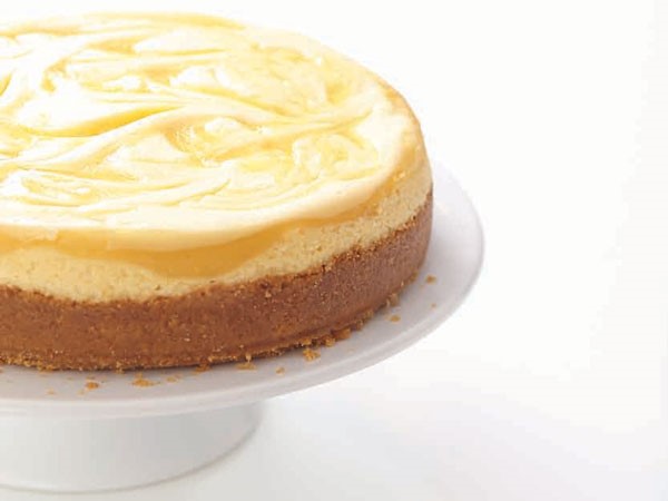 Graham cracker crust cheesecake topped with cream filling and a swirled lemon curd