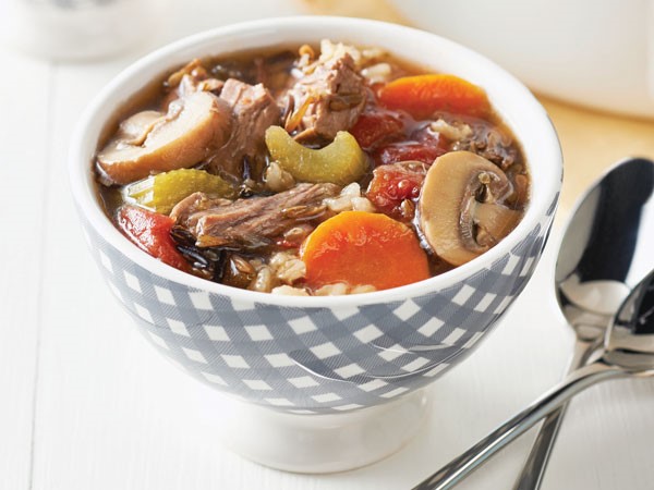 Hearty beef stew with celery, mushrooms, and carrots in soup bowl