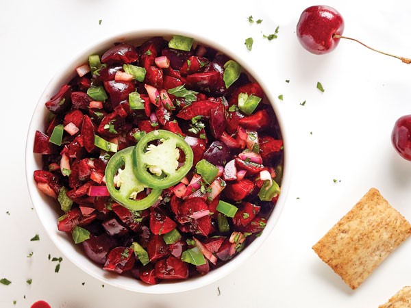 Bowl of sweet cherries mixed with red onion, cilantro and jalapeno