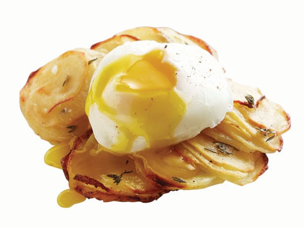 Sliced potatoes topped with poached egg