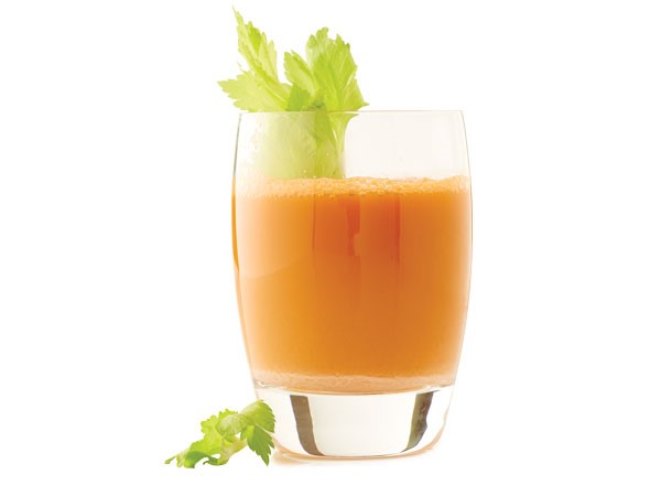 Glass of carrot crush garnished with celery stalk