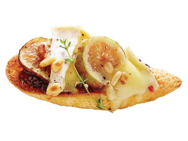 Crostini slice topped with brie, fig and pine nuts