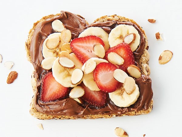 9-grain bread smothered in chocolate-hazelnut spread and topped with sliced bananas, strawberries and almonds