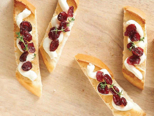 Wooden plank of cranberry-mascarpone toasts