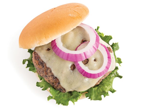Turkey burger on lettuce, topped with melted cheese and red onion