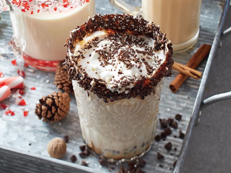 Chocolate-covered espresso beans and sprinkle-rimmed glass filled with cinnamon-mocha eggnog