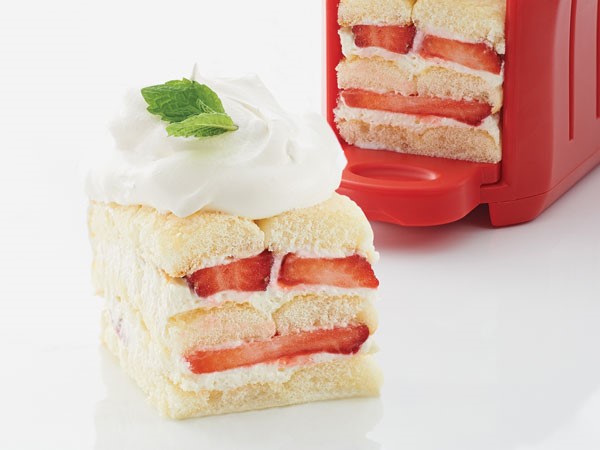 Ladyfingers piled together, filled with cream and fresh strawberries and garnished with a dollop of whipped topping and a mint leaf