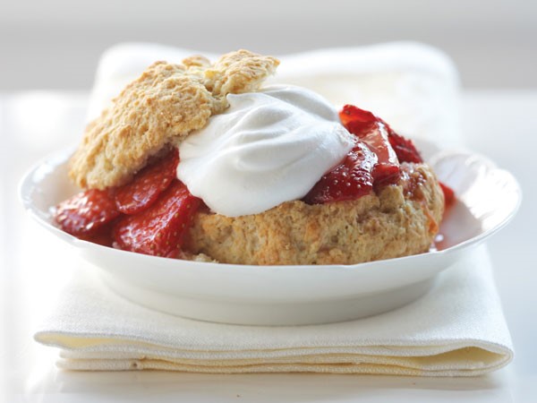 Shortcake garnished with whipped topping and fresh strawberries