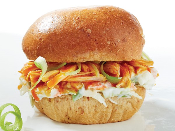Shredded chicken with buffalo sauce and coleslaw sandwiched between a bun