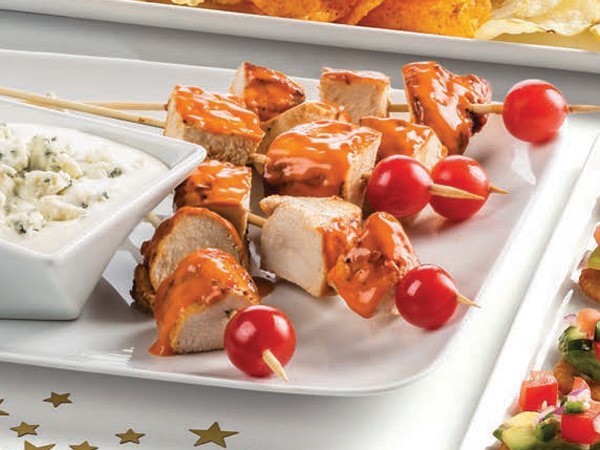 Buffalo chicken skewers with cherry tomatoes and side dish of bleu cheese dip