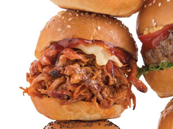 Pulled pork with BBQ sauce and cheese sandwiched between a slider bun