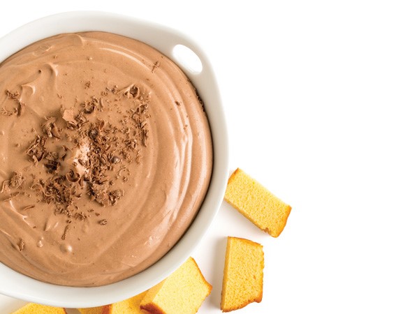 Chocolate dip with chocolate shavings in a white bowl and a side of cubed pound cake