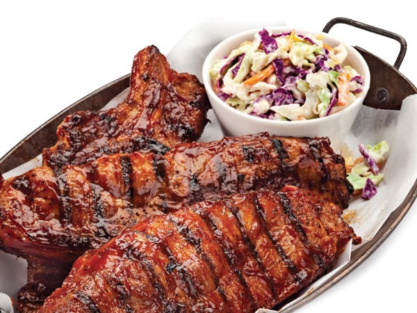 Dish of saucy country pork ribs with side of coleslaw