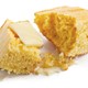 Piece of cornbread pulled apart with square of butter on top