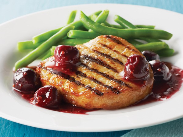 Grilled pork chop topped with cherry sauce