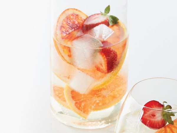 Glass of citrus-berry sangria filled with sliced grapefruit and strawberries
