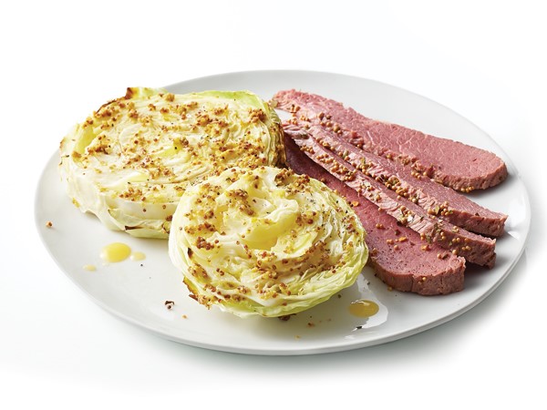 Plate of seasoned corned beef with baked cabbage steaks