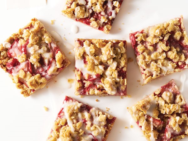 Strawberry oatmeal bars drizzled with white glaze and topped with oatmeal crumbs