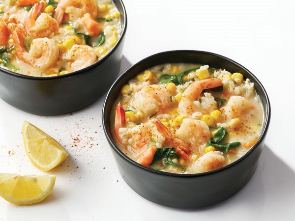 Two cups of chowder filled with corn, shrimp and spinach