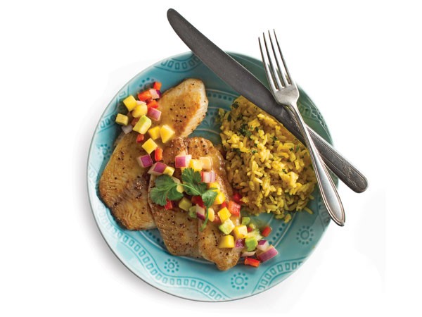 Blue plate filled with tilapia covered in fruit salsa, served with a side of rice