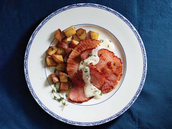 Sliced ham with potatoes and white gravy sauce