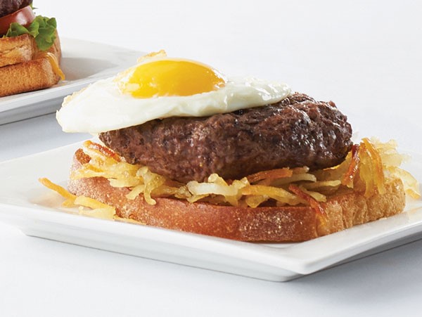 Gourmet burger served atop a bed of hashbrowns and toast and topped with a sunny side up egg