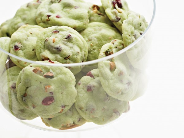 Green pistachio cherry cookies in clear glass bowl