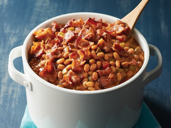 Pot of bacon-and-salsa baked beans with a wooden spoon