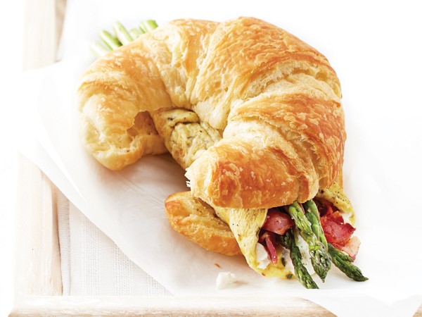 Asparagus omelet sandwiched between a sliced croissant