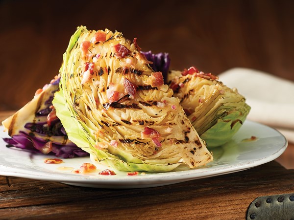 Plate of cabbage topped with bacon-mustard dressing