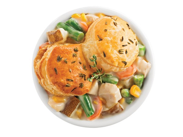 Bowl of chicken pot pie topped with two biscuits