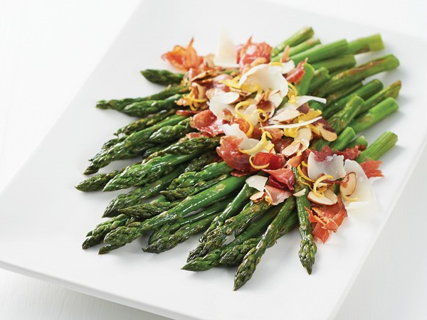 Platter of asparagus topped with crispy prosciutto, almonds, Parmigiano-Reggiano cheese and lemon zest