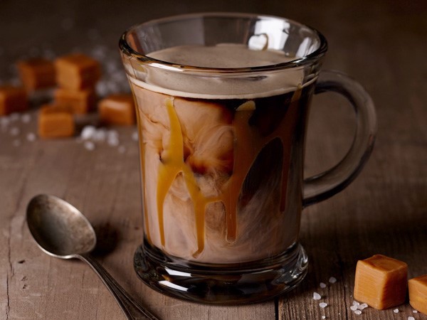 Clear mug filled with caramel sauce and creamy Irish stout cocktail
