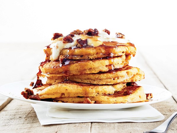 Stack of pumpkin praline pancakes on white plate