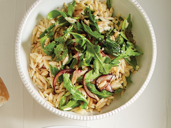 Bowl of orzo, arugula and red onions