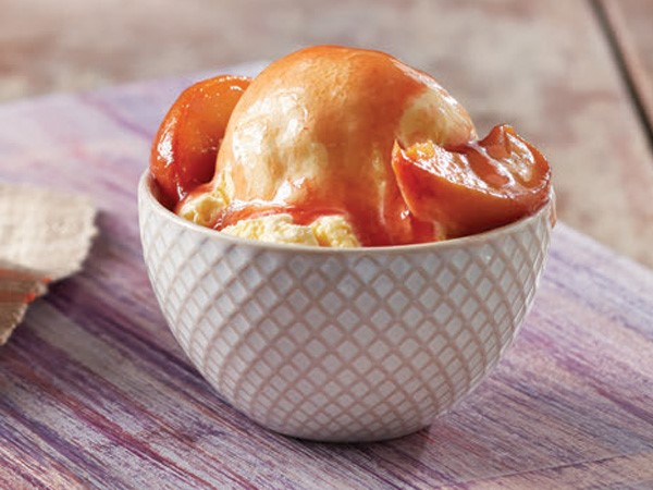 Peachy plum sauce on top of vanilla ice cream