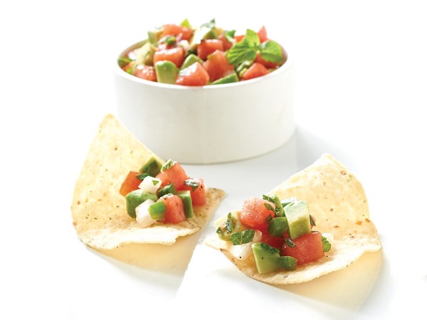 Tortilla chip filled with avocado melon salsa