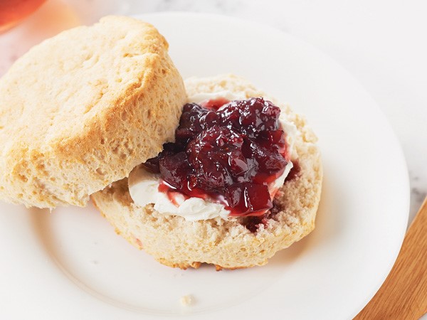 Biscuit topped with whipped cream and blackberry-chipotle jam