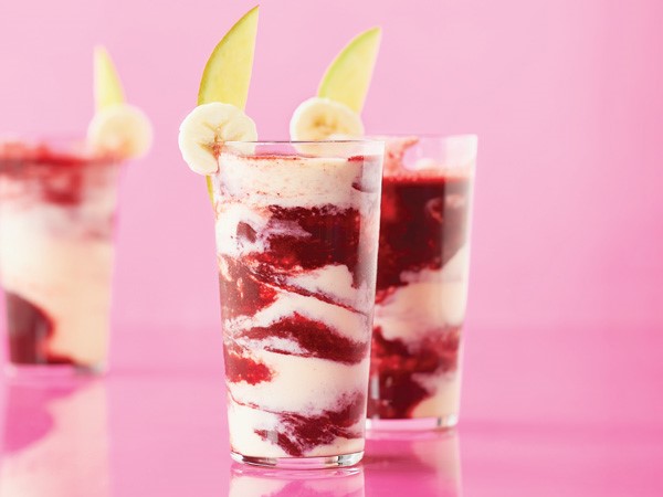 Glasses of cherry-mango smoothies garnished with banana and mango slices